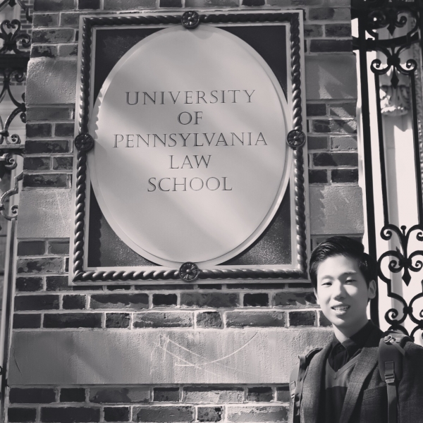 Chan Woo standing next to a sign that says University of Pennsylvania Law School.