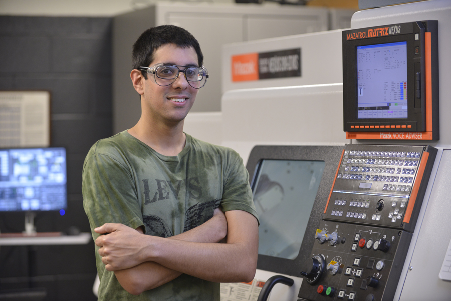 Odanis Rodriguez in front of a CNC controller