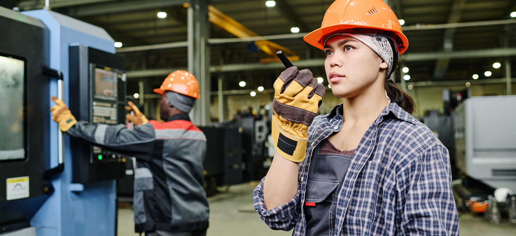 Female industrial management worker on walkie-talkie